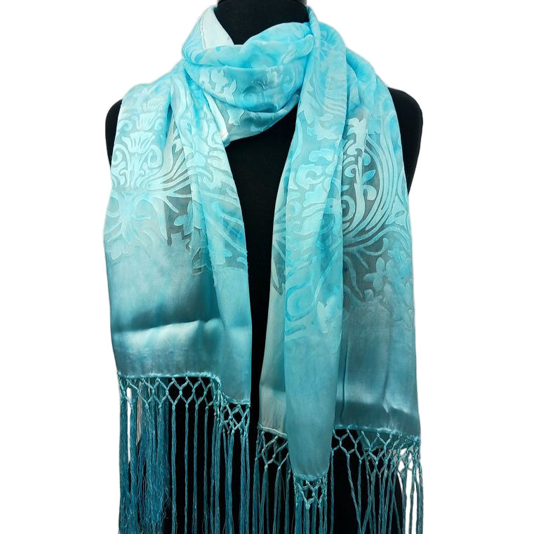 A turquoise scarf with a floral pattern displayed on a mannequin.