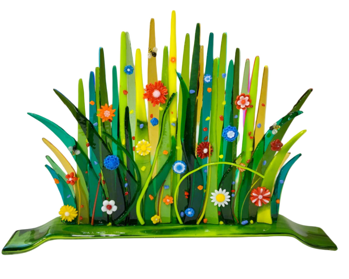 Colorful glass sculpture of grass and flowers on a white background