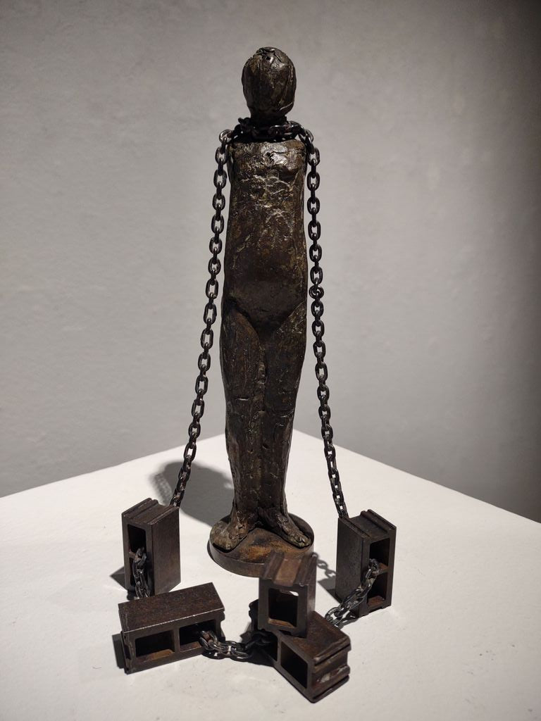 Figure Chained to Cement Blocks